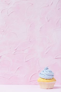 Cupcake pastel pembe bir arka plan üzerinde Menekşe buttercream ile dekore edilmiştir. Tatlı güzel pasta. Dikey afiş, düğün, doğum günü, kadınlar günü için tebrik kartı. Fotoğraf kadar kapatın. Seçici odak