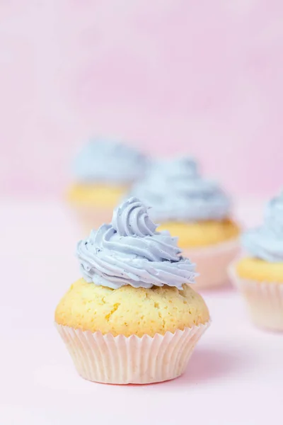 Cupcake decorado com creme de manteiga violeta em fundo rosa pastel. Doce bolo lindo. Banner vertical, cartão de felicitações para aniversário, casamento, dia das mulheres. Fotografia de perto. Foco seletivo — Fotografia de Stock