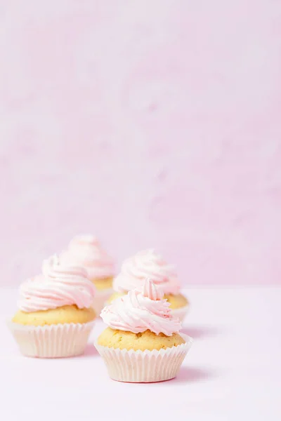컵 케 익 장식 파스텔 핑크 바탕에 분홍색 buttercream. 달콤한 아름 다운 케이크입니다. 수직 배너, 생일, 결혼식, 여성의 날 인사말 카드. 사진을 닫습니다. 선택적 초점 — 스톡 사진