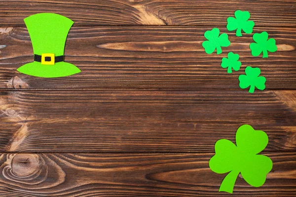 St. Patrick dzień tematu kolorowy poziomy baner. Krasnoludek zielony kapelusz i shamrock pozostawia na brązowym tle drewnianych. Produkt jest wytwarzanie elementów. Kopiować miejsca. Dla karty z pozdrowieniami, baner gratulacje — Zdjęcie stockowe