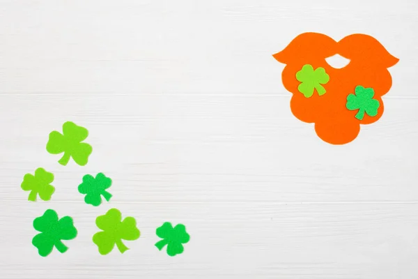 St. Patrick dzień tematu kolorowy poziomy baner. Krasnoludek pomarańczowy rękodzieło brodę i shamrock zielonych liści na białym tle drewnianych. Produkt jest wytwarzanie elementów. Kopiować miejsca. Dla karty z pozdrowieniami transparent — Zdjęcie stockowe