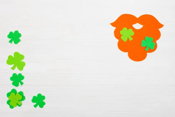 St. Patrick dzień tematu kolorowy poziomy baner. Krasnoludek pomarańczowy rękodzieło brodę i shamrock zielonych liści na białym tle drewnianych. Produkt jest wytwarzanie elementów. Kopiować miejsca. Dla karty z pozdrowieniami transparent — Zdjęcie stockowe