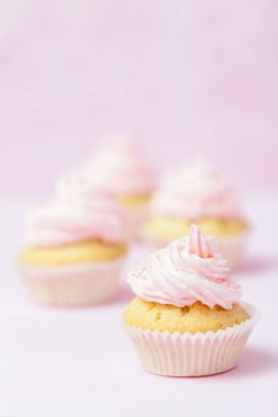 Cupcake pastel pembe bir arka plan üzerinde pembe buttercream ile dekore edilmiştir. Tatlı güzel pasta. Dikey afiş, düğün, doğum günü, kadınlar günü için tebrik kartı. Fotoğraf kadar kapatın. Seçici odak