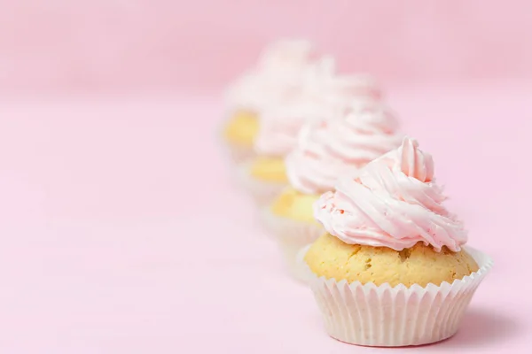 Cupcake decorated with pink buttercream on pastel pink background. Sweet beautiful cake. Horizontal banner, greeting card for birthday, wedding, women\'s day. Close up photography. Selective focus