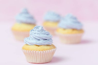 Cupcake pastel pembe bir arka plan üzerinde Menekşe buttercream ile dekore edilmiştir. Tatlı güzel pasta. Yatay banner, düğün, doğum günü, kadınlar günü için tebrik kartı. Fotoğraf kadar kapatın. Seçici odak