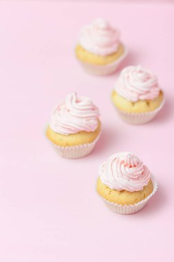 Cupcake pastel pembe bir arka plan üzerinde pembe buttercream ile dekore edilmiştir. Tatlı güzel pasta. Dikey afiş, düğün, doğum günü, kadınlar günü için tebrik kartı. Fotoğraf kadar kapatın. Seçici odak