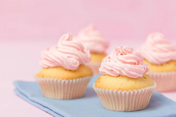 カップケーキ ピンク buttercream パステル ピンク背景に飾られています。甘い美しいケーキ。水平型バナーは、誕生日、結婚式、女性の日のグリーティング カード。写真を閉じます。選択と集中 — ストック写真