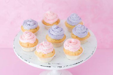 Pastel pembe Pembe ve mor üzerinde eski püskü shic krem ile cupcakes standı.