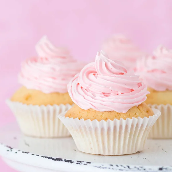 Cupcake decorat cu cremă de unt roz pe fundal roz pastel . — Fotografie, imagine de stoc