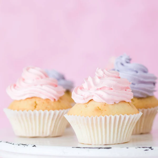 Cupcakes decorate cu cremă de unt violet roz pe stand shic shabby pe fundal pastel roz . — Fotografie, imagine de stoc