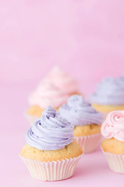 Cupcakes decorate cu cremă de unt roz și violet în picioare pe fundal roz pastel — Fotografie, imagine de stoc