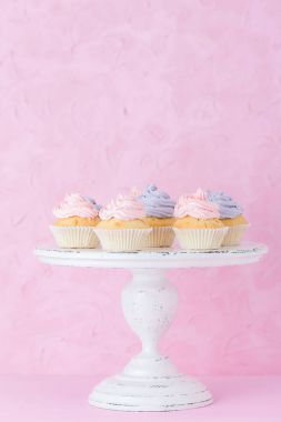 Pastel pembe Pembe ve mor beyaz eski püskü shic krem ile cupcakes standı.