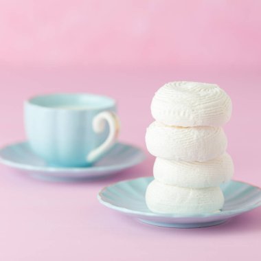 Pastel pembe kare afiş ile mavi tabak ve bardak süt beyaz zephyr.