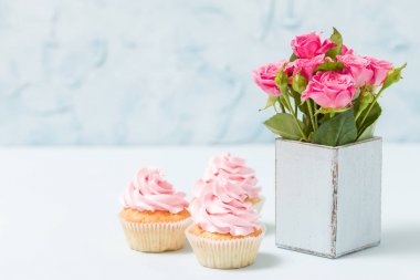 Cupcake pembe krem dekorasyon ve retro eski püskü şık vazoda pembe Gül.