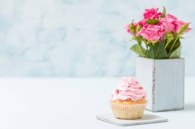 Cupcake pembe dekorasyon ve retro eski püskü şık vazoda pembe gül buketi.