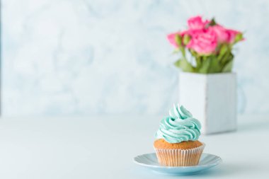 Cupcake pembe dekorasyon ve retro eski püskü şık vazoda pembe gül buketi.