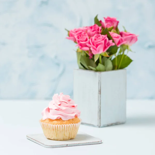 Cupcake with pink decoration and bouquet of pink roses in retro shabby chic vase. — Stock Photo, Image