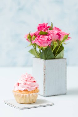 Cupcake pembe dekorasyon ve retro eski püskü şık vazoda pembe gül buketi.