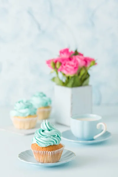 Bandeira vertical pastel azul com cupcakes decorados, xícara de café com leite e buquê de rosas rosa . — Fotografia de Stock