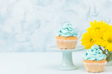 Vintage stand ve gözlük vazoda sarı Kasımpatı buket sarı krem dekorasyonu ile cupcake.