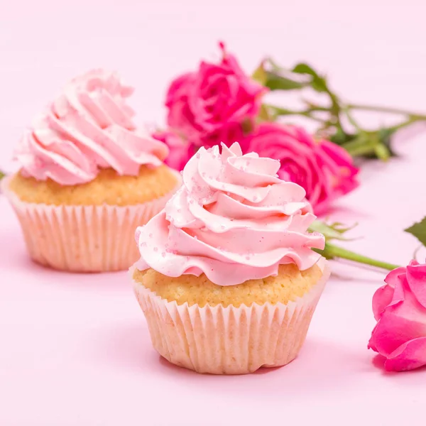 Cupcake with pink cream decoration and roses on pink pastel background. — Stock Photo, Image