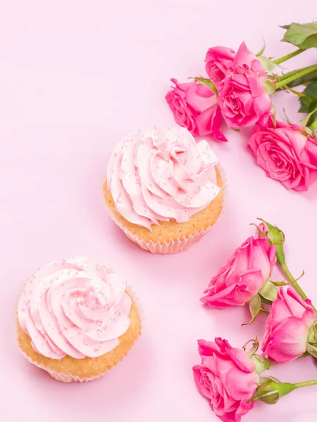 Cupcake with pink cream decoration and roses on pink pastel background. — Stock Photo, Image