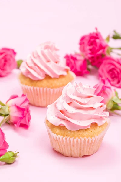 Cupcake com decoração de creme rosa e rosas em fundo pastel rosa . — Fotografia de Stock