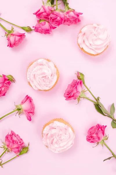 Cupcake com decoração de creme rosa e rosas em fundo pastel rosa . — Fotografia de Stock