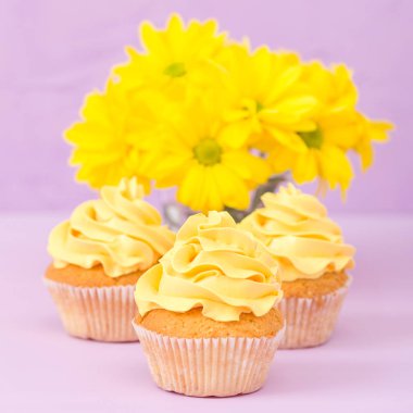 Sarı krem ve Kasımpatı Menekşe pastel arka planda tebrik kartı copyscape ile süslenmiş cupcakes.
