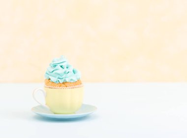 Cupcake plaka - sarı pastel yatay afiş mavi krem dekorasyonu ile. Minimalizm natürmort kavramı.
