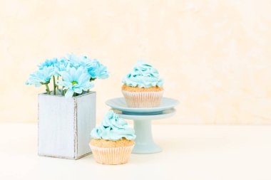 Tatlı mavi buttercream dekorasyon ve mavi krizantem retro eski püskü şık vazoda ile cupcake.