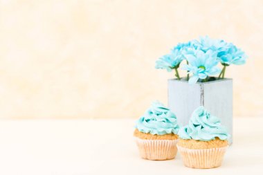 Tatlı mavi buttercream dekorasyon ve mavi krizantem retro eski püskü şık vazoda ile cupcake.