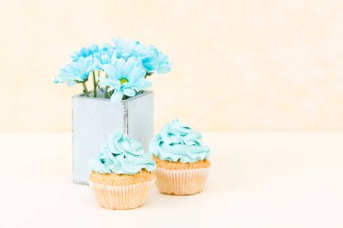Tatlı mavi buttercream dekorasyon ve mavi krizantem retro eski püskü şık vazoda ile cupcake.