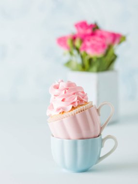 Mavi pastel afiş ile dekore edilmiş çörekler ve pembe gül buketi.