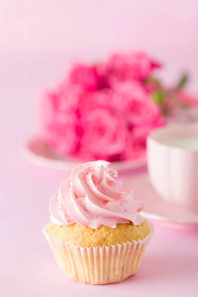 Cupcake with pink cream decoration and roses on pink pastel background. — Stock Photo, Image