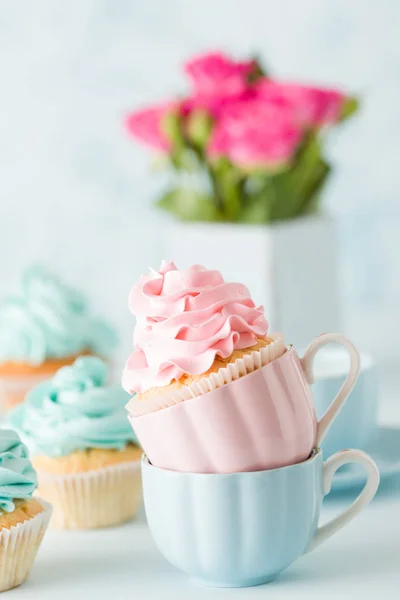 Синій пастельний банер з прикрашеними кексами, чашкою кави з молоком і букетом рожевих троянд . — стокове фото