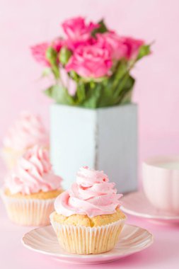 Pembe pastel dikey afiş ile dekore edilmiş cupcakes, sütlü kahve fincan ve pembe gül buketi.