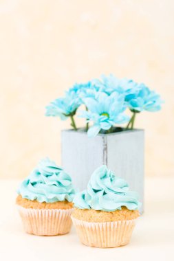 Tatlı mavi buttercream dekorasyon ve mavi krizantem retro eski püskü şık vazoda ile cupcake.