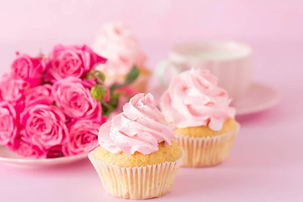 Cupcake with pink cream decoration and roses on pink pastel background. — Stock Photo, Image