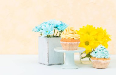 Kekler eski püskü şık vazoda sarı ve mavi krizantem ihale krema ile dekore edilmiştir. Copyscape alan