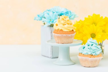 Kekler eski püskü şık vazoda sarı ve mavi krizantem ihale krema ile dekore edilmiştir. Copyscape alan