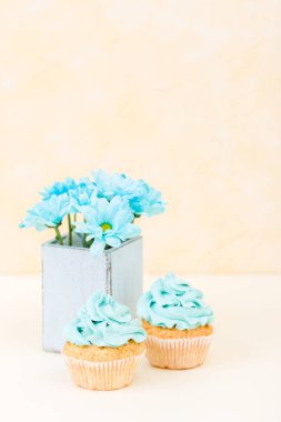Tatlı mavi buttercream dekorasyon ve mavi krizantem retro eski püskü şık vazoda ile cupcake.