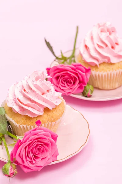 Cupcake with pink cream decoration and roses on pink pastel background. — Stock Photo, Image