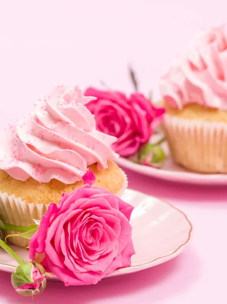 Cupcake with pink cream decoration and roses on pink pastel background. — Stock Photo, Image