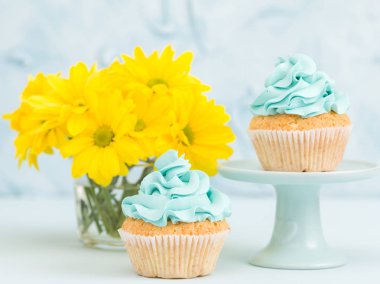 Vintage stand ve gözlük vazoda sarı Kasımpatı buket sarı krem dekorasyonu ile cupcake.