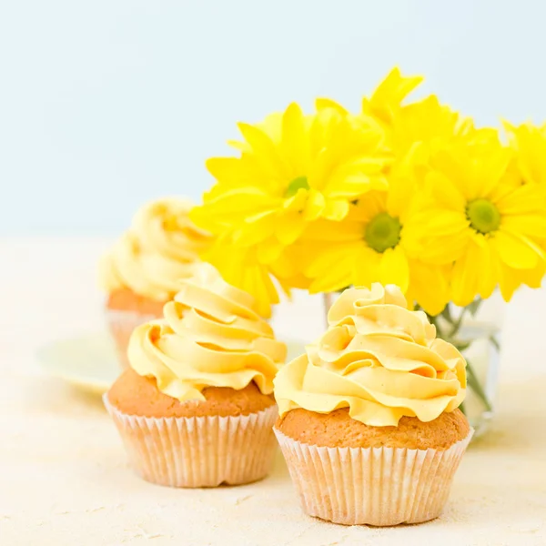 Cupcake com doce decoração creme amarelo e buquê de crisântemo amarelo em vidro pequeno — Fotografia de Stock