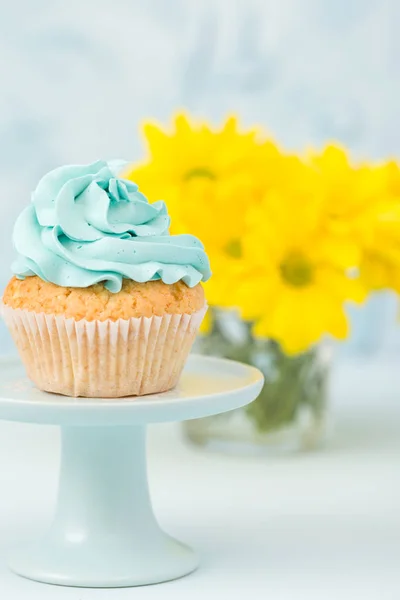 Vintage stand ve gözlük vazoda sarı Kasımpatı buket mavi krem dekorasyonu ile cupcake. — Stok fotoğraf