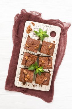 Brownie tatlı çikolata tatlı ceviz ve retro kurulu demek yapraklarda pastel bej renkli arka plan üzerinde kopya alanı ile.