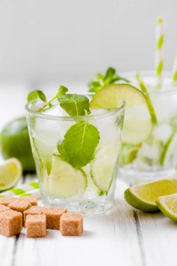 Yaz kokteyl mojito limon ve nane Beyaz ahşap antika arka planda yenileniyor. Taze yaz yeşil yaprakları güzel gözlük narenciye ve güzel kokulu içkiyle buzlu.