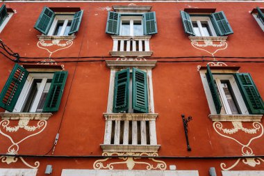 Rovinj, Hırvatistan için windows üzerinde yeşil panjurlar ile dekore edilmiş kırmızı ev cephe.